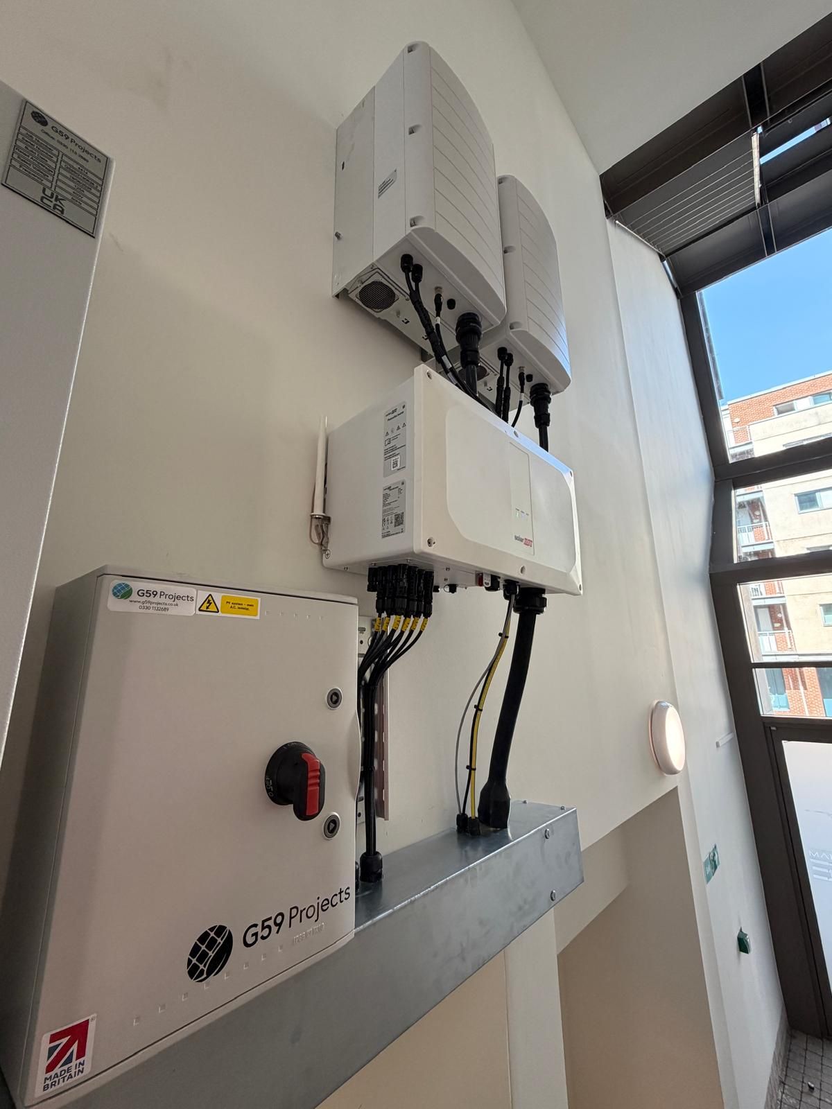 Neatly wired inverter and monitoring equipment inside a commercial solar installation