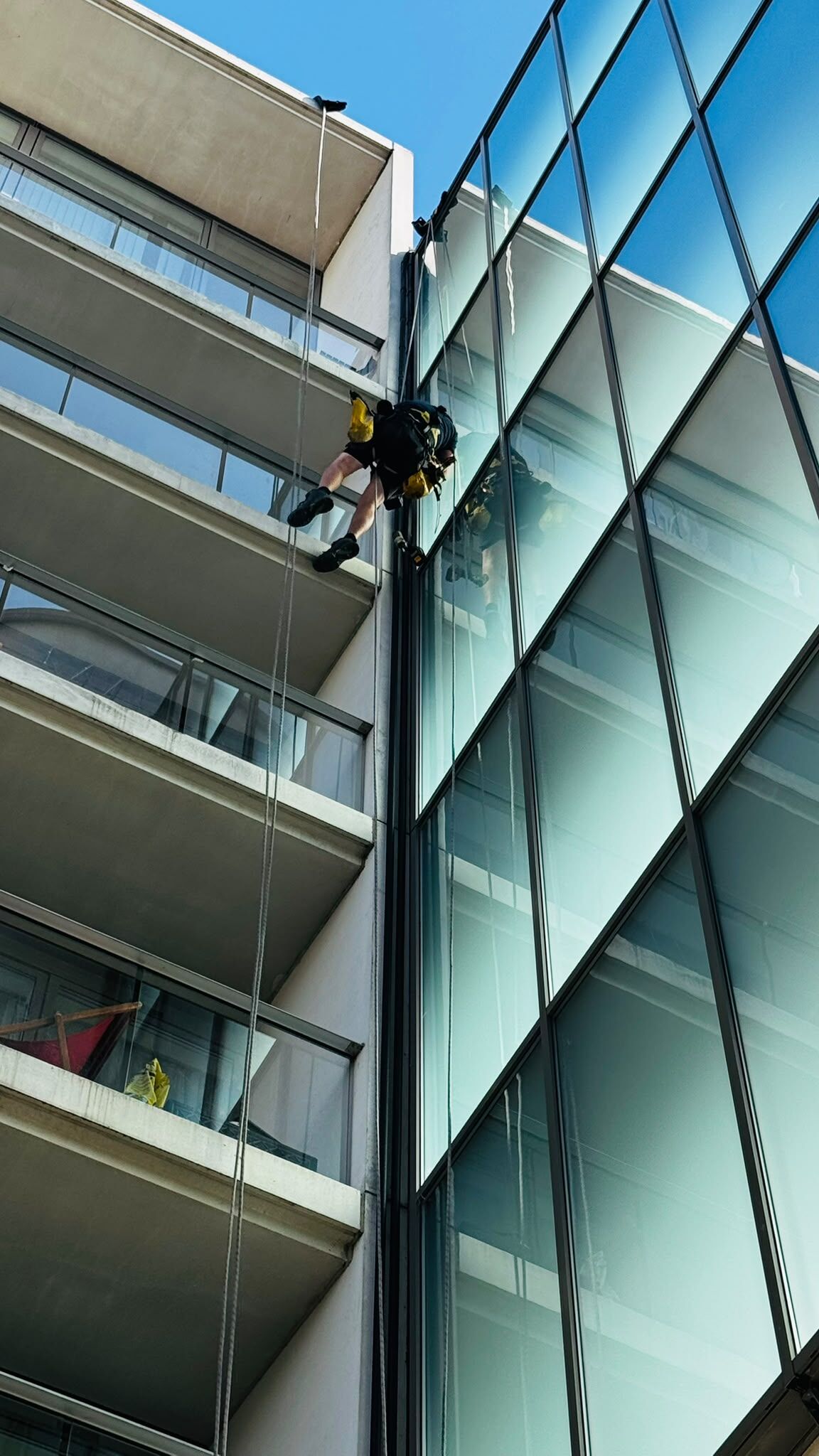 Specialist abseiler installing solar cabling down the exterior of a Nottingham building
